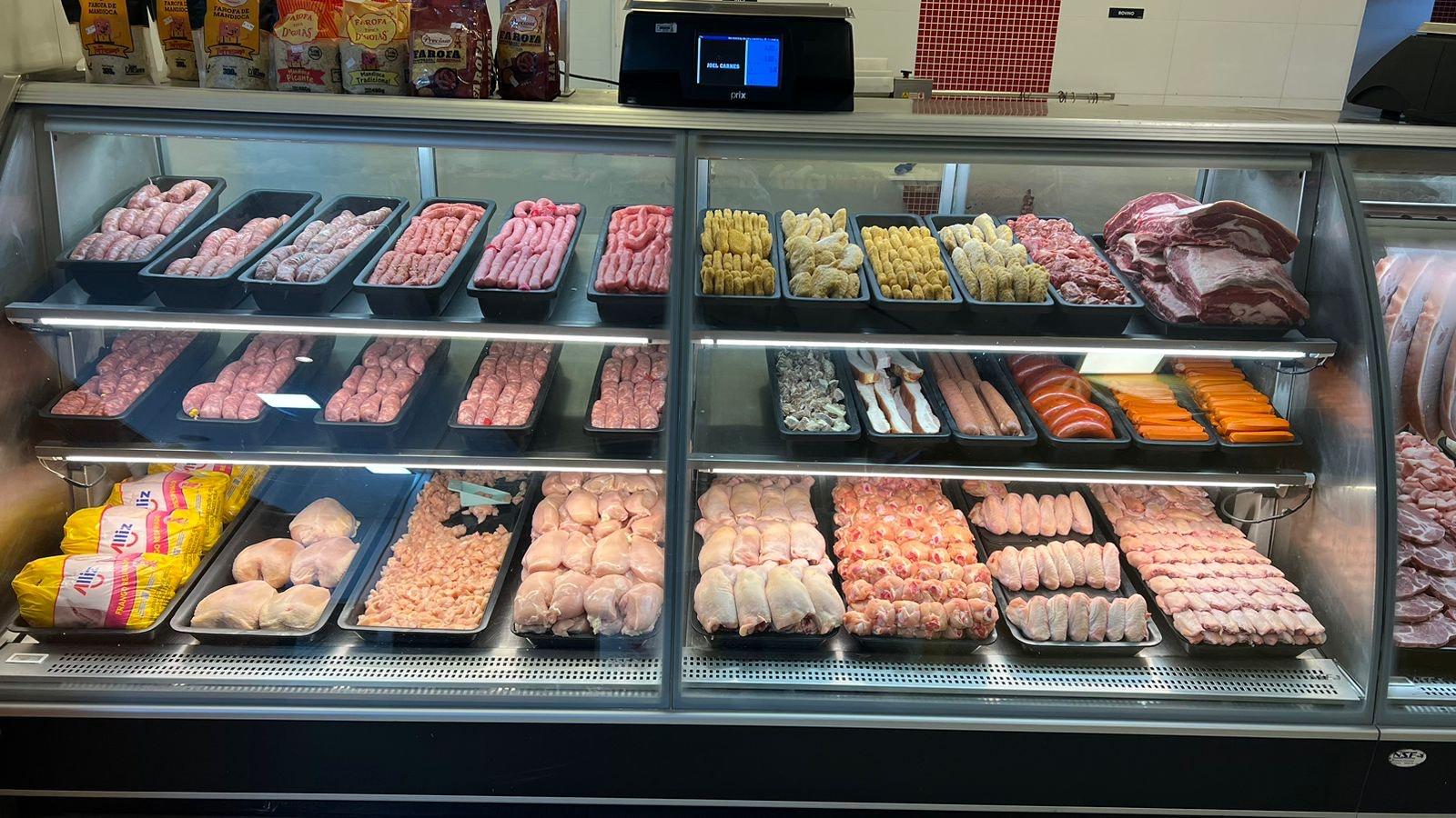 açougue limpo com balcão refrigerado organizado e cortes de carne bovina